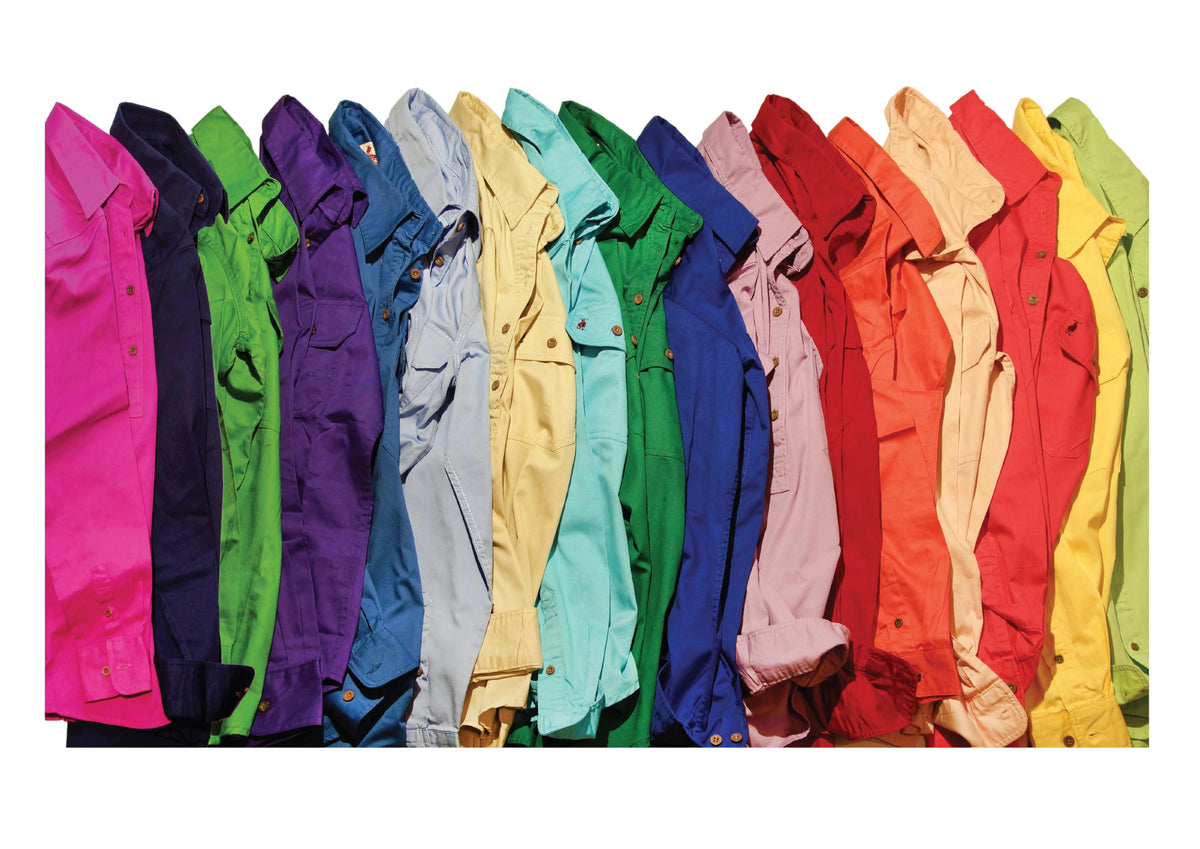 A row of Nungar Workshirts in a rainbow colour palette, including pink, navy, green, purple, light blue, yellow, teal, dark green, blue, pink, red, orange, beige, and yellow, displayed against a solid white background.